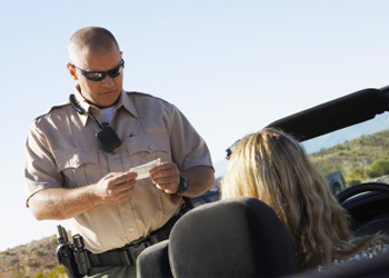 Traffic citation for speeding being issued to driver by Michigan Highway Patrol officer