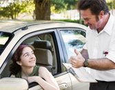 Teen driver leaning out of window looking at driving instructor